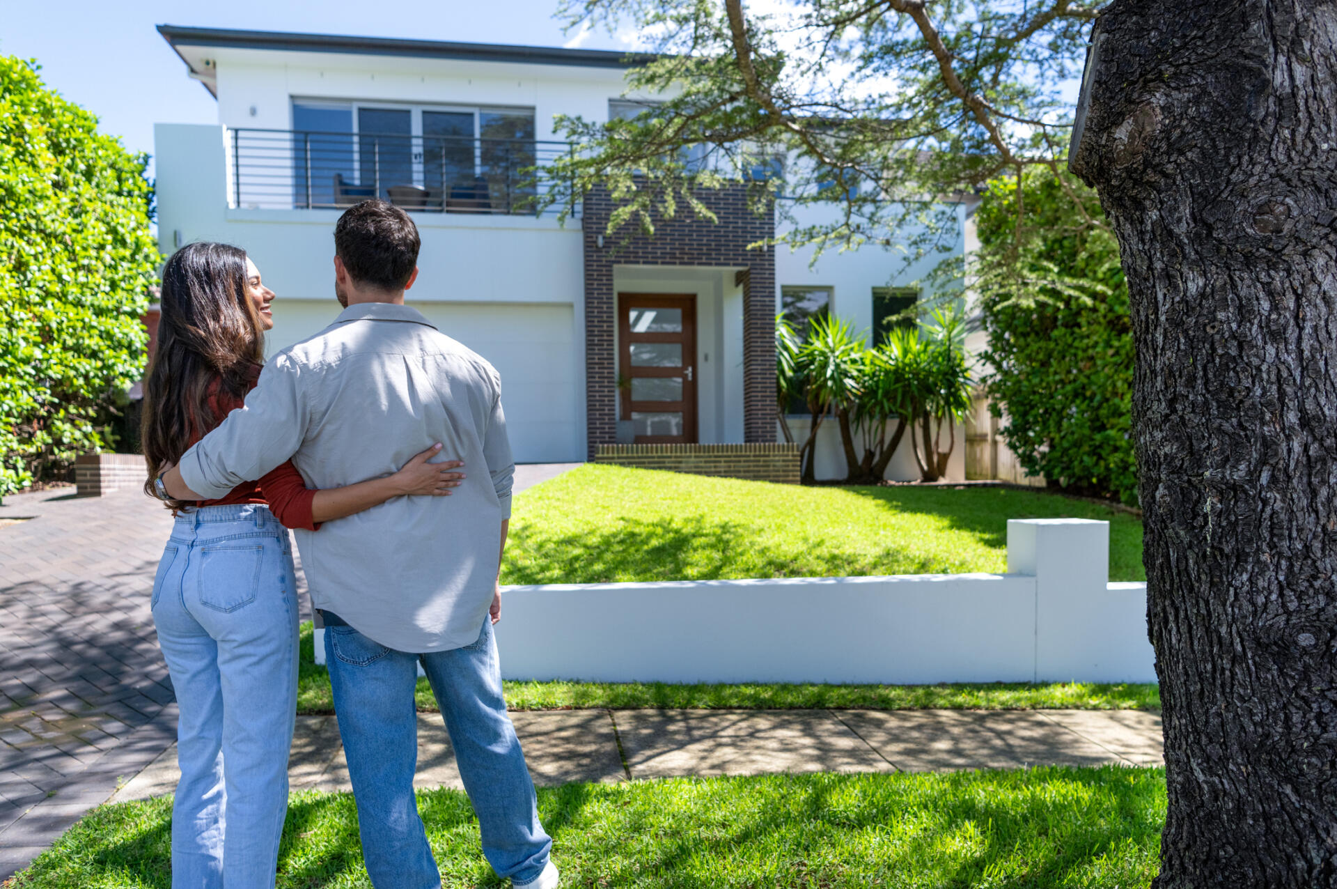 Happy Couple standing in front of their new home.
