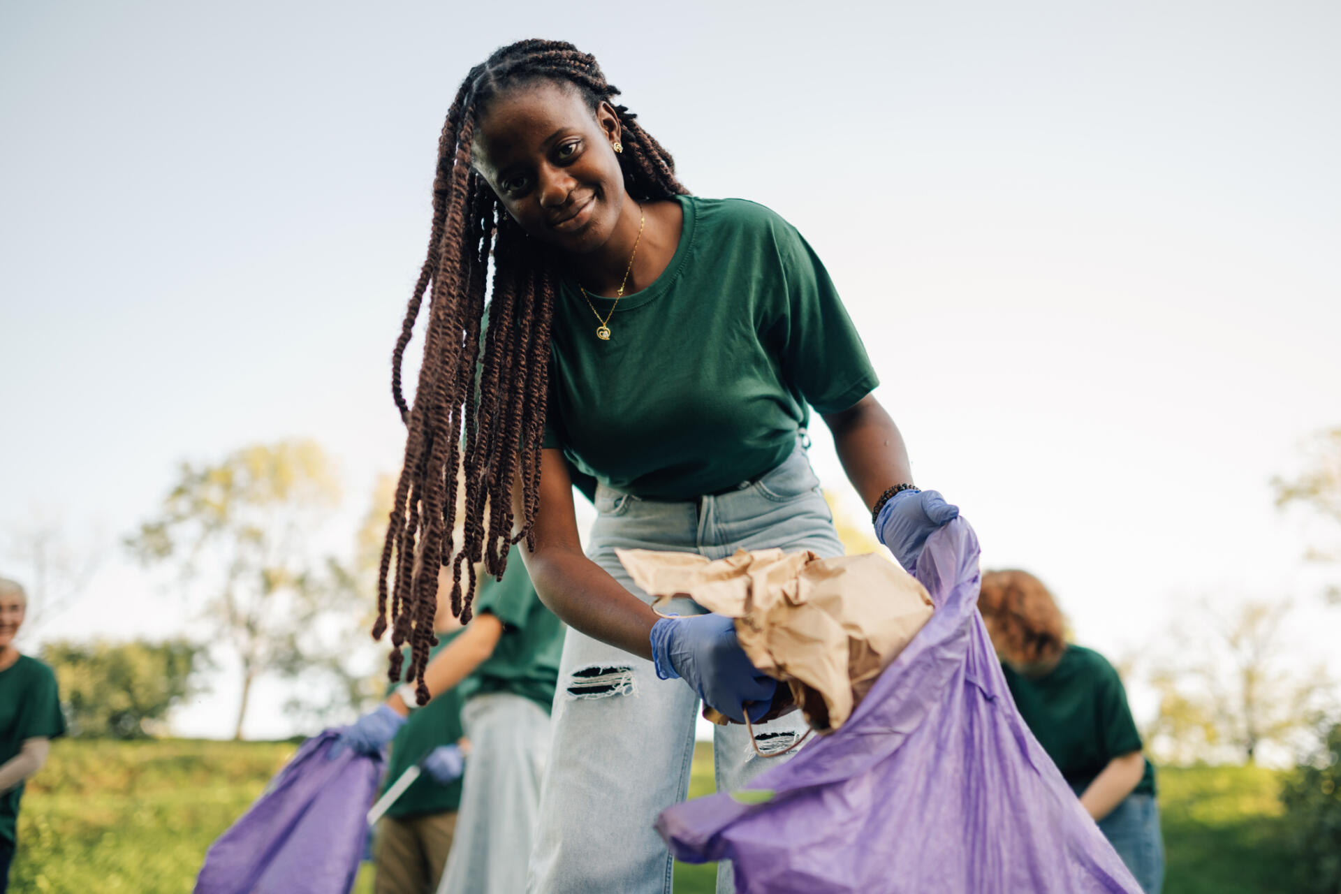 Young woman volunteer picking up trash in park