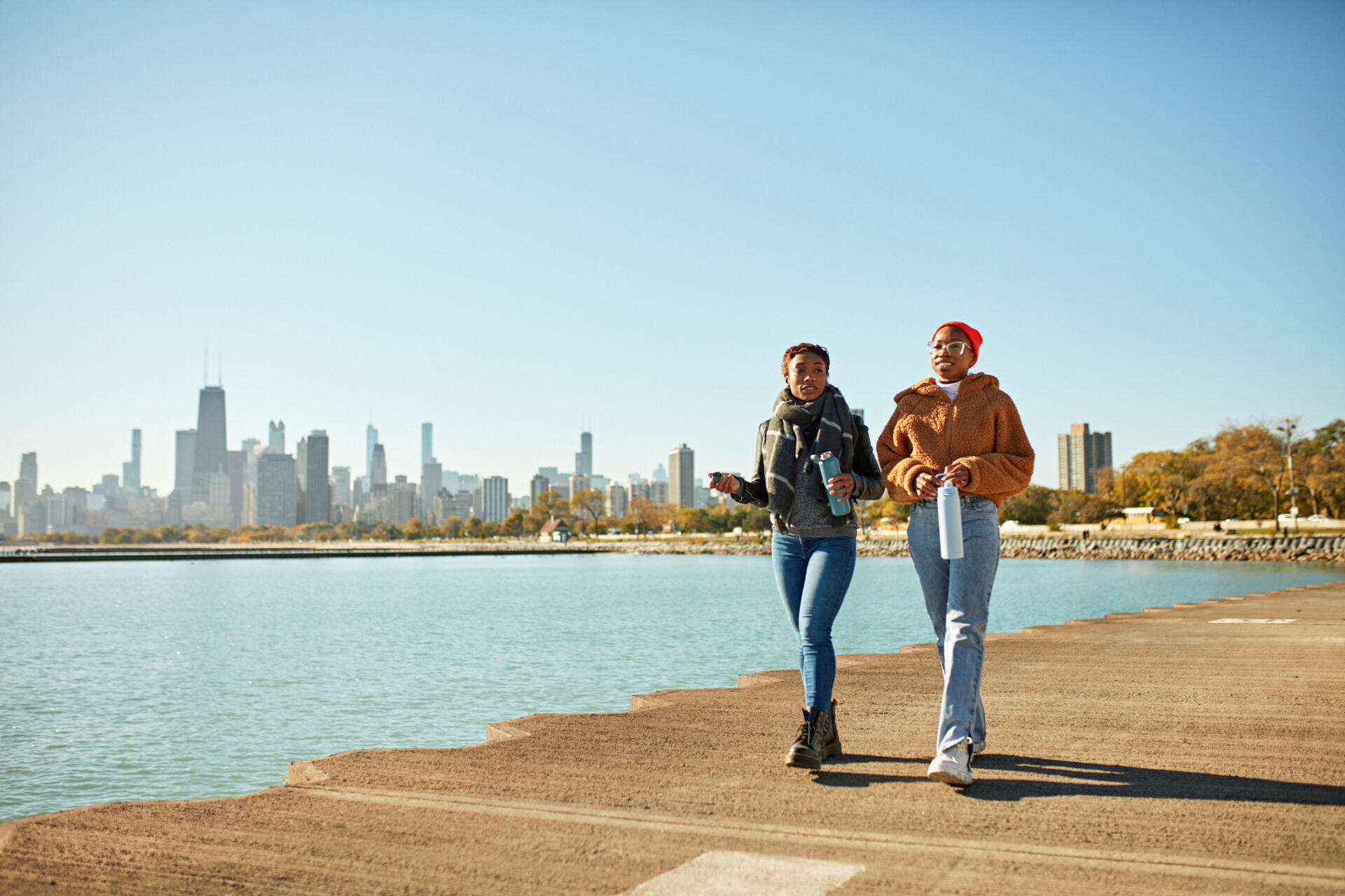 Female friends walking for exercise along Lake Michigan in Chicago