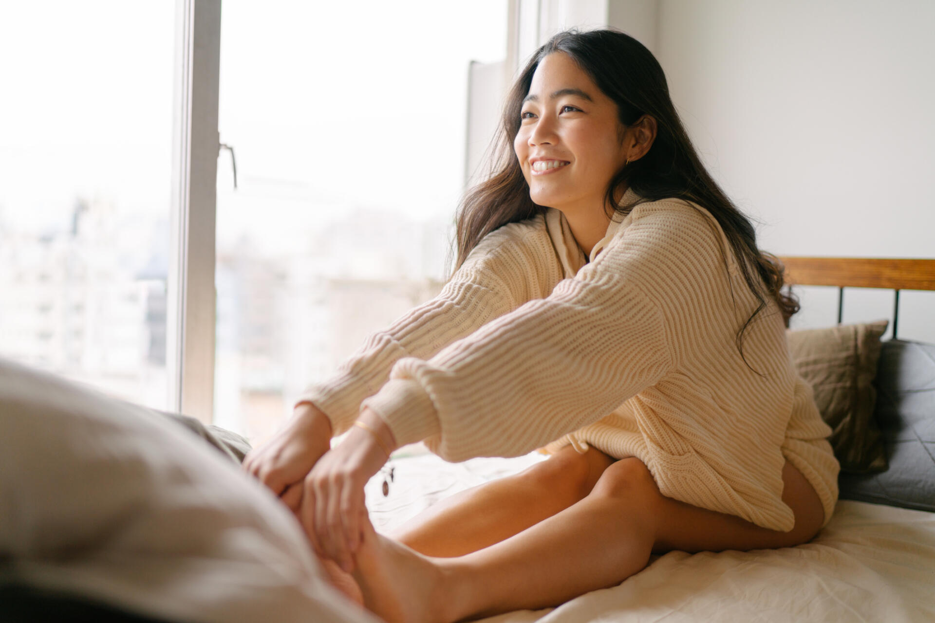 Young woman stretching her legs in the morning on her bed