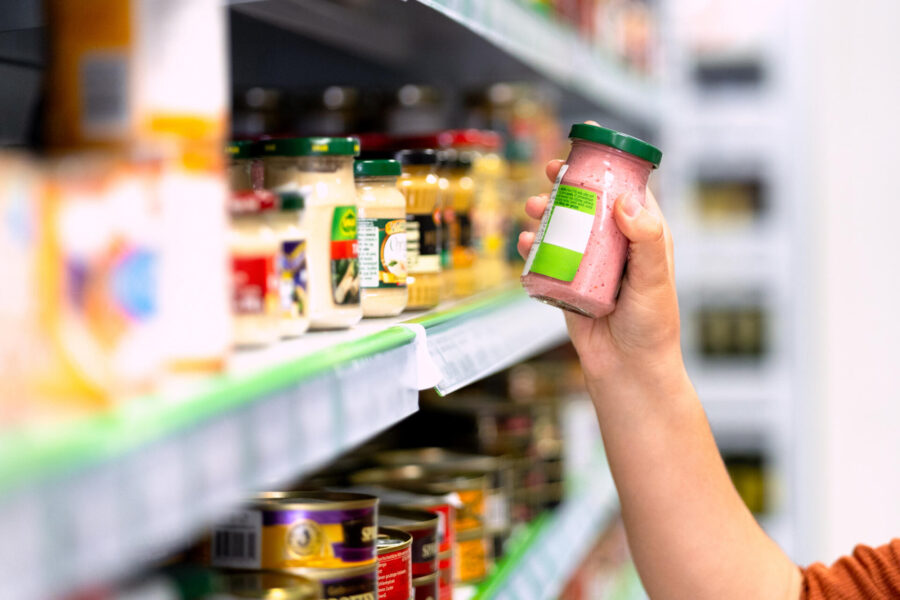 Stock Your Fridge and Pantry Right With These Tips 2 Woman picking up product in the supermarket while grocery shopping