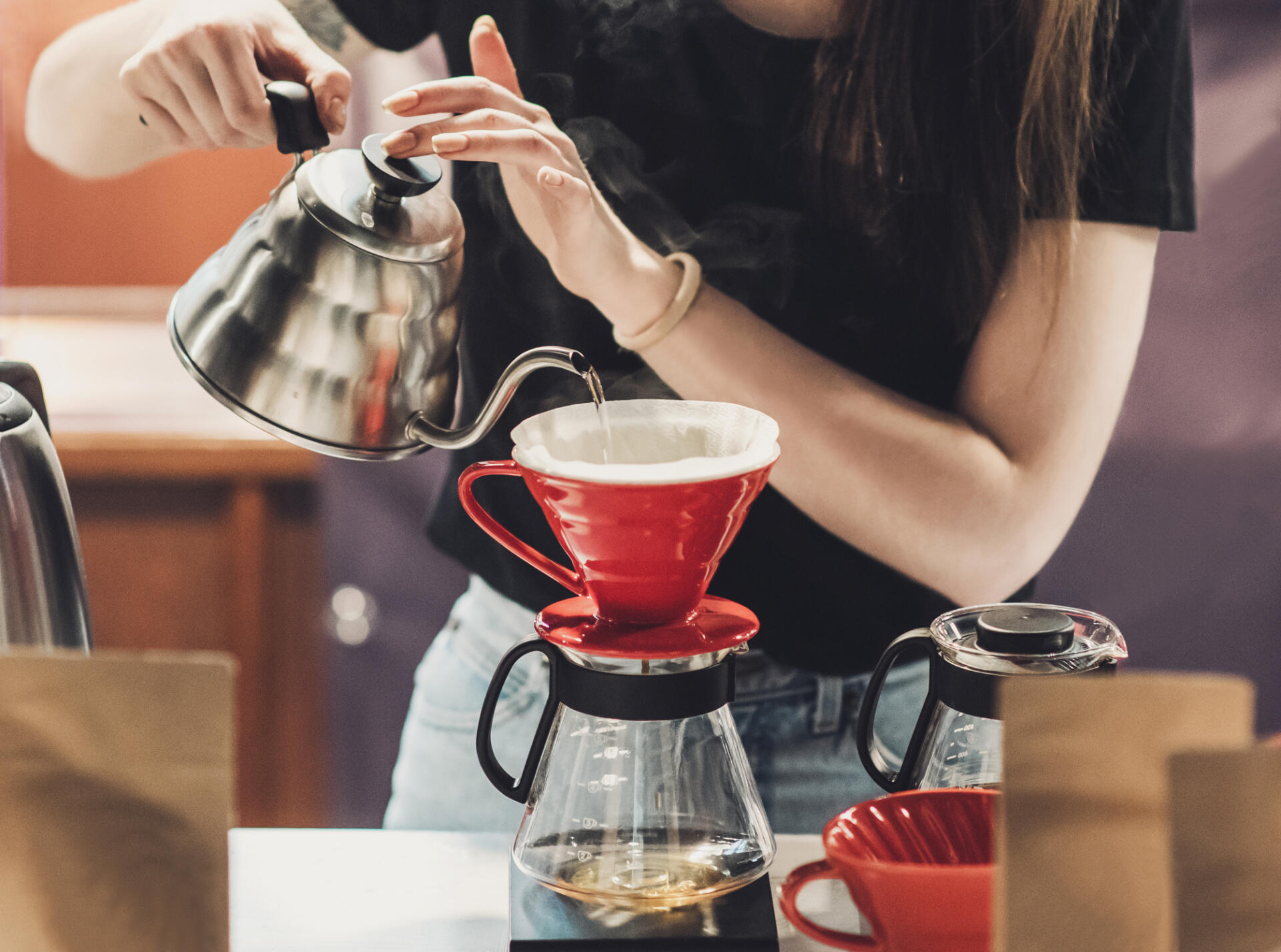 Barista pouring water into a pour-over coffee maker